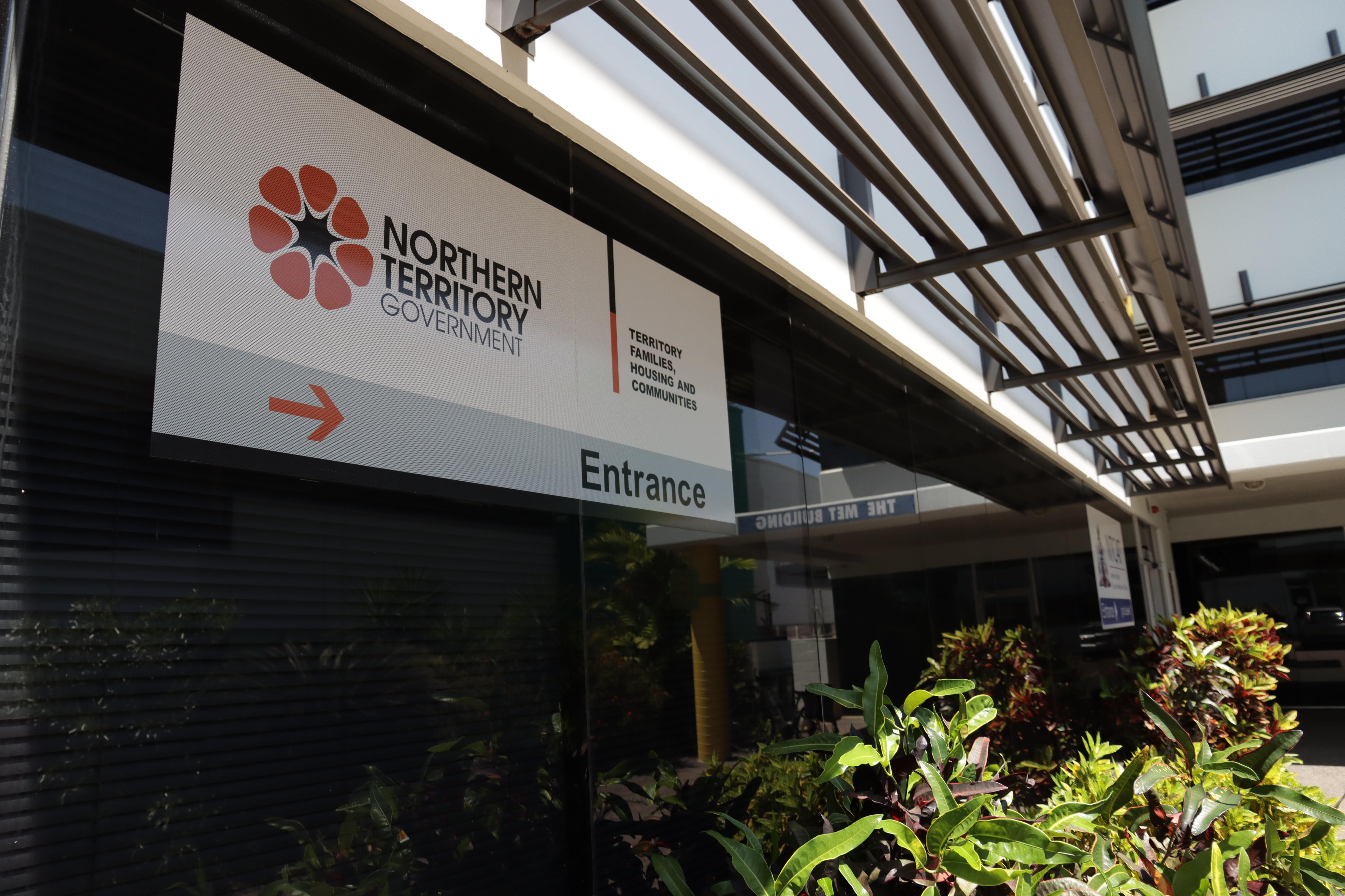 A sign showing the way to the Territory Families office, inside a large office building.