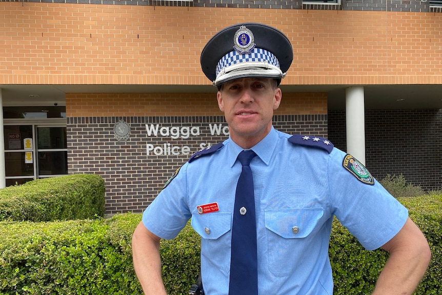 Policeman stands outside Wagga Wagga Police Station with hands on hips.