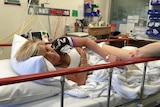 Sharon Heinrich laying in a hospital bed