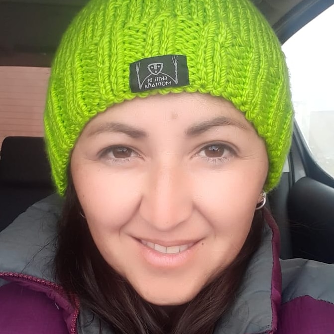 A close-up image of a woman's face. She's wearing a lime green beanie. 
