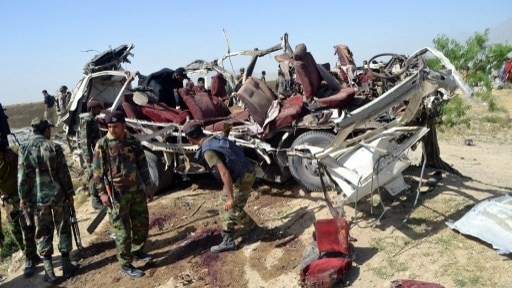 Pakistani security official examine the destroyed vehicle following a bomb attack