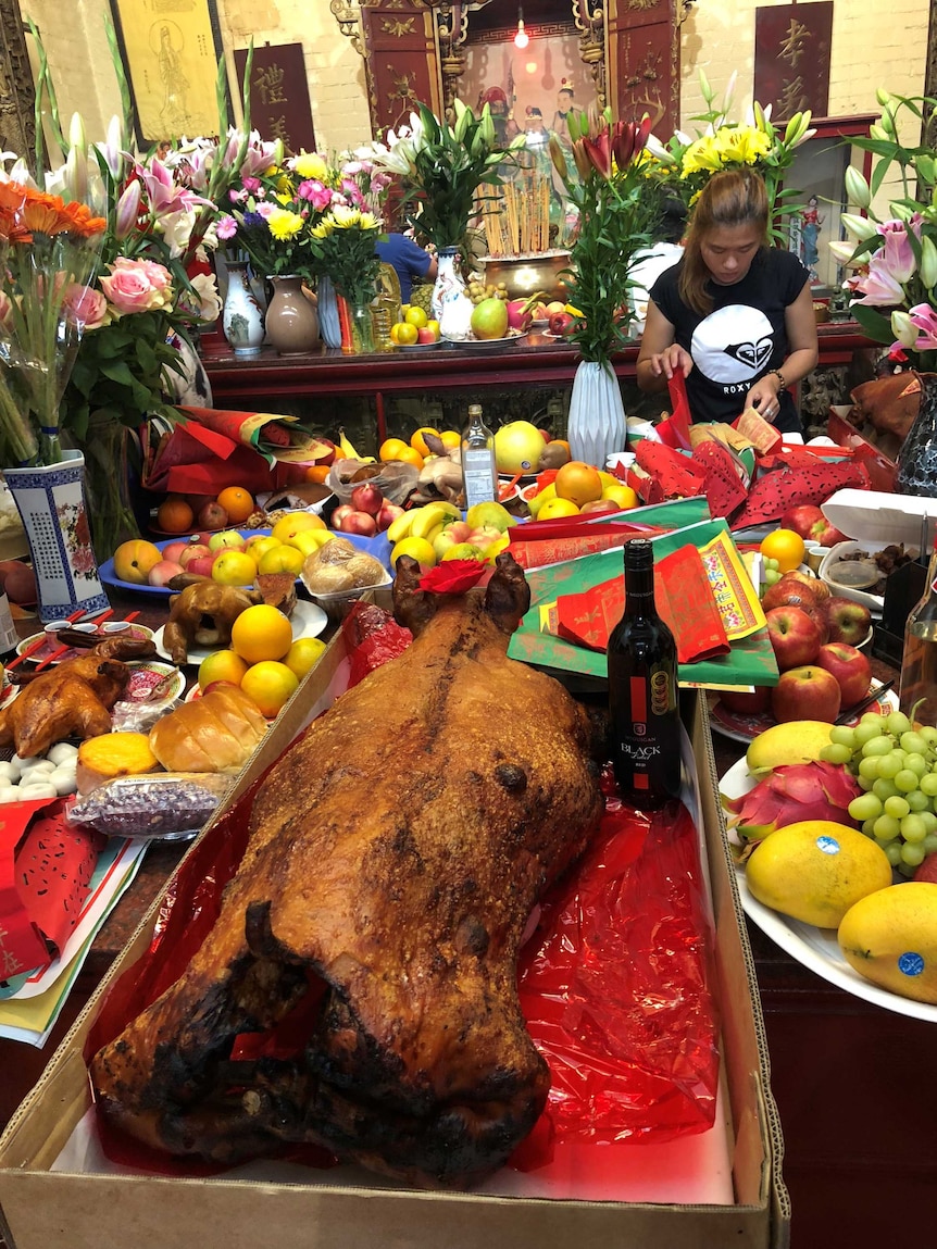 A whole roast pork on an alter table at a buddhist temple