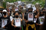 Anti-coup protesters holding pictures of those who died during a protest