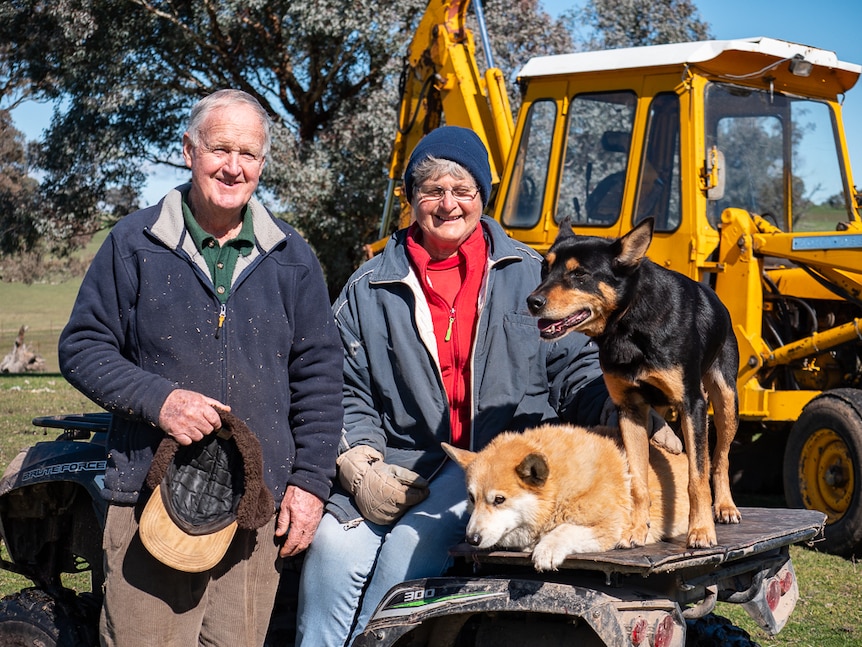 David and Robyn Kingham with farm dogs sitting on an all terrain vehicle.