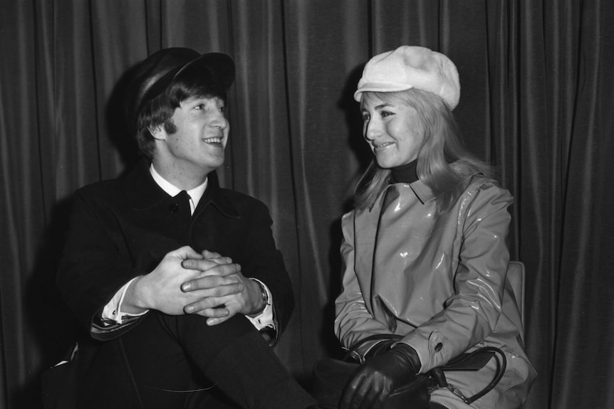 black and white image of a man and a woman sitting on chairs looking at each other