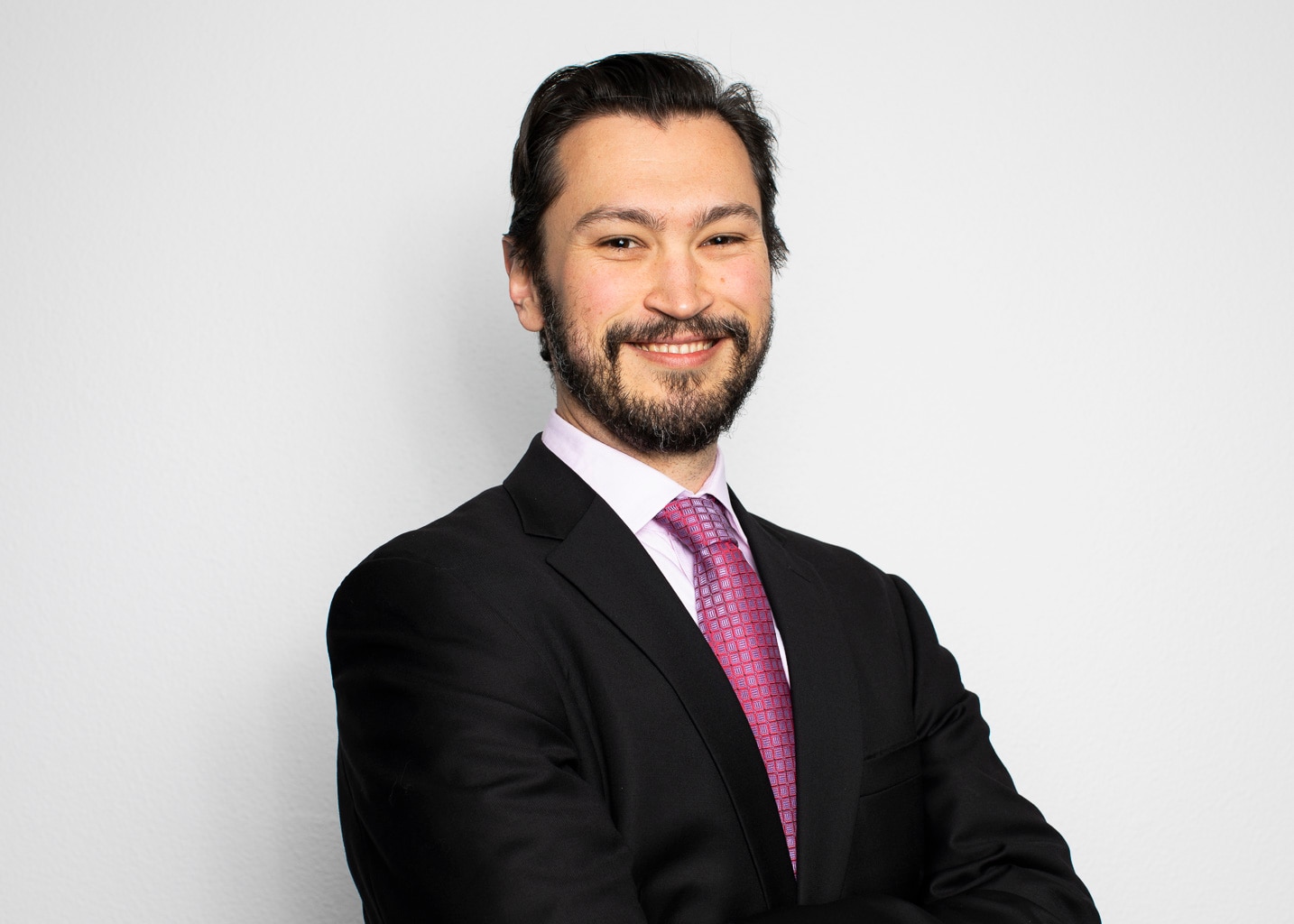 A man wearing a suit and tie smiling at the camera. 