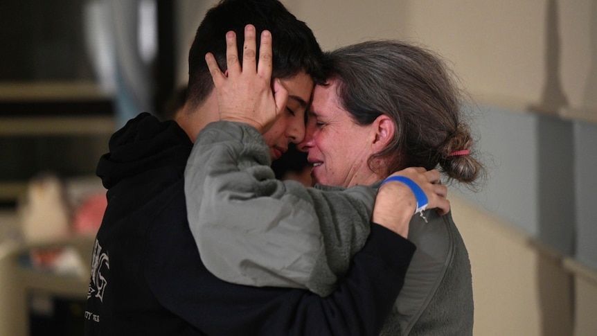 A woman and a man hugging, crying. 