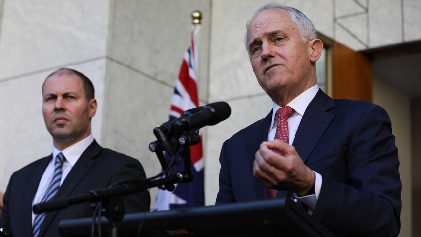 Mr Turnbull is mid sentence, gesticulating with his left hand. Mr Frydenberg watches on.