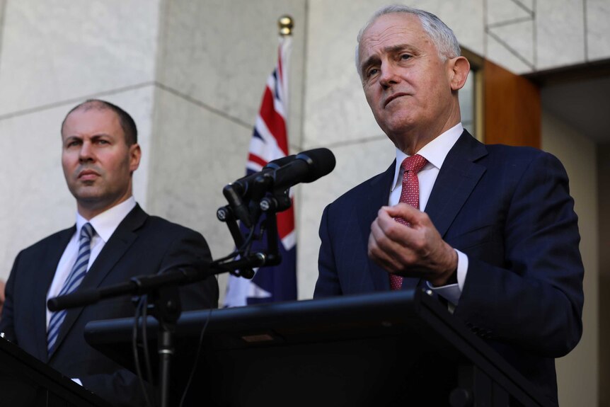 Mr Turnbull is mid sentence, gesticulating with his left hand. Mr Frydenberg watches on.