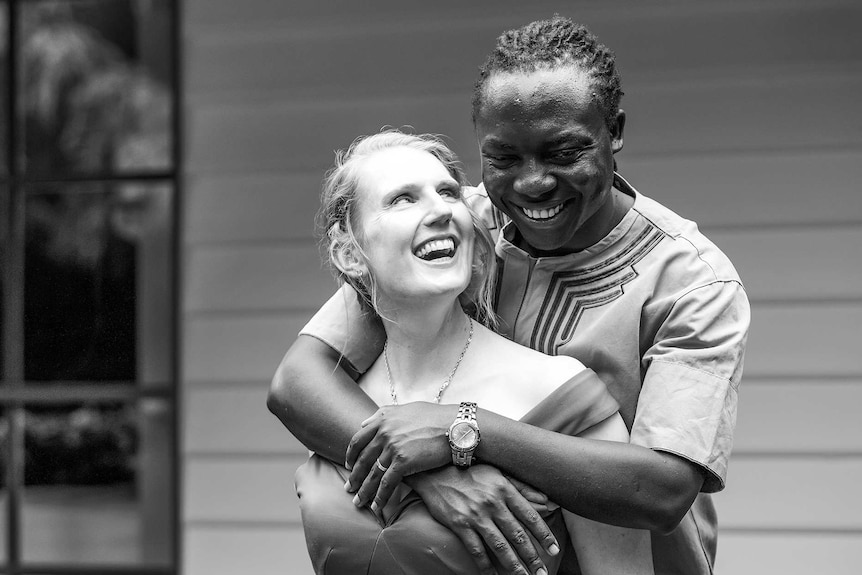 Celia and Moses Audi embrace in a black and white portrait.