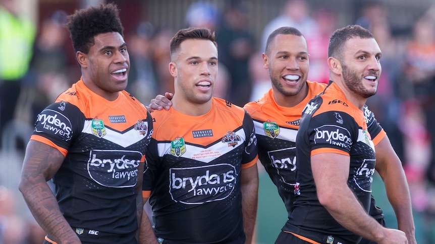 Wests Tigers celebrate a Luke Brooks try against the Dragons.
