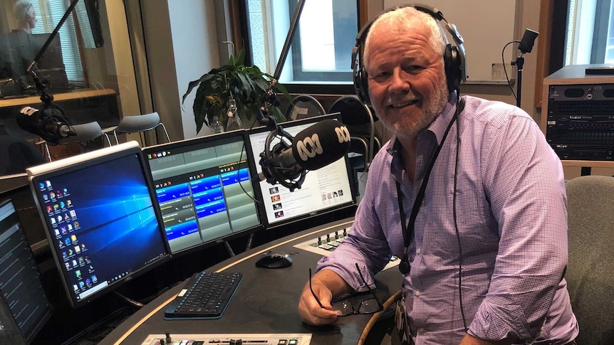 A man wearing headphones in a radio studio.