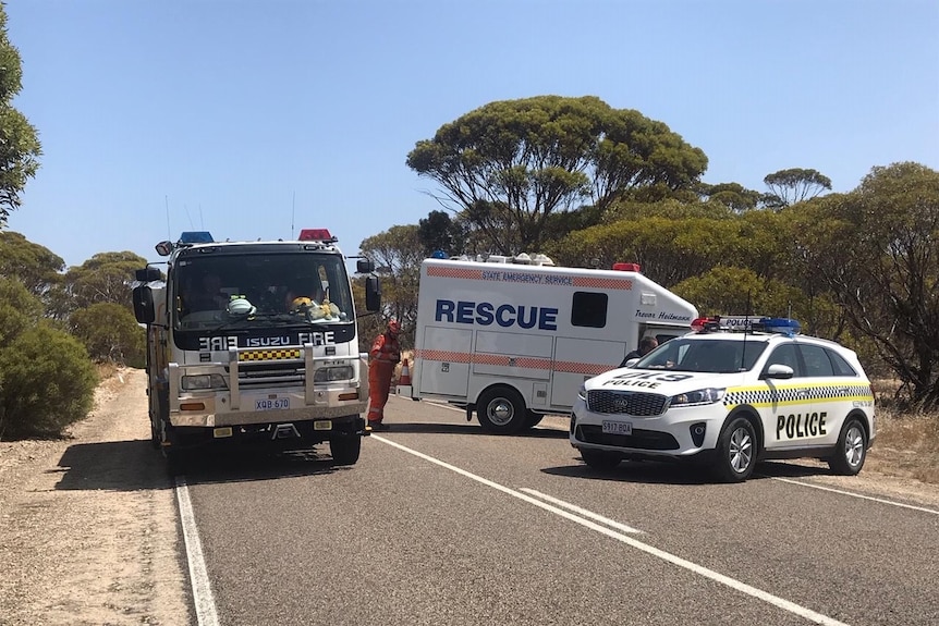 A fire truck, an SES rescue vehicle and a police car block a country road