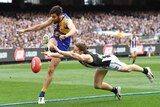 Tom Langdon attempts to smother a Josh Kennedy kick in the AFL grand final.