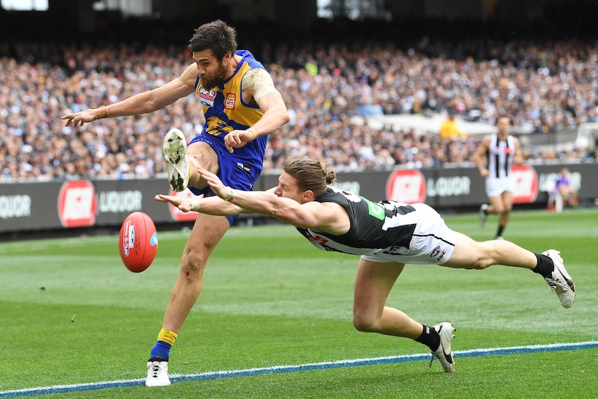 Tom Langdon attempts to smother a Josh Kennedy kick in the AFL grand final.