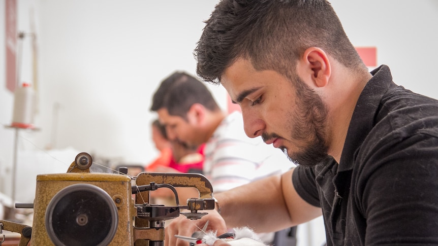 Syrian refugee Dilo Maho working on a sewing machine in Toowoomba.