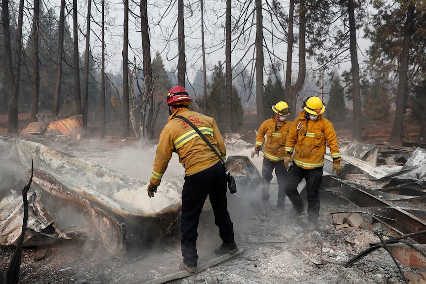 A group of firefighters inspect a burnt out property in northern California.