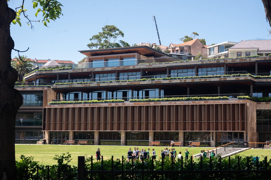 The multi-storey buildings of Cranbrook School. In the foreground is an oval with some unidentifiable students on it.