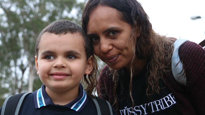 Deborah Lonsdale smiles and leans down to pose with young son Cameron