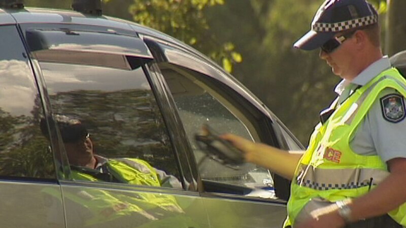 A Qld policeman conducts a random breath test.