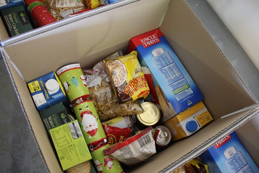 A box of food items such as noodles and long life milk.