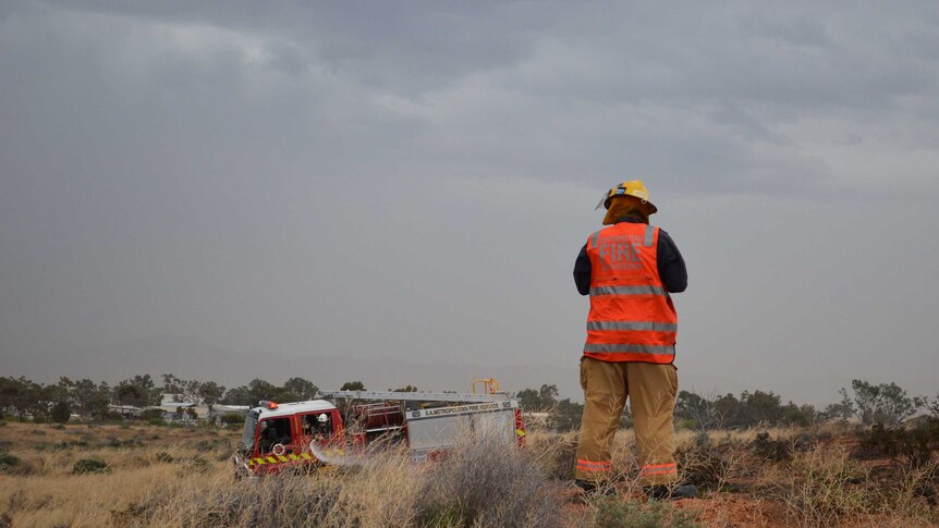 MFS station officer Darren McNamee watches a burnt area for any hotspots after a grass fire on the outskirts of Port Augusta.