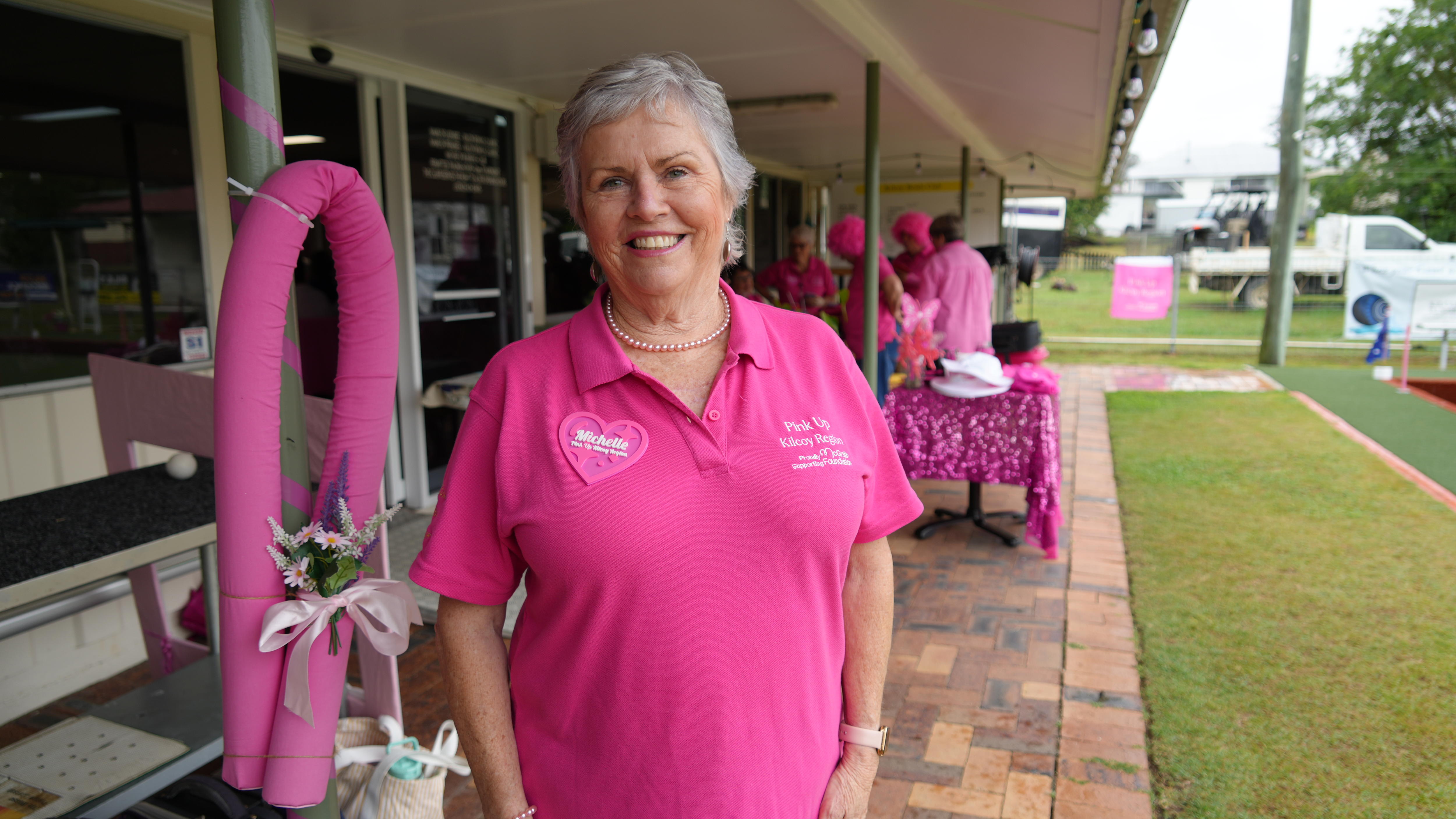 Elderly woman wearing pink smiling at bowls club
