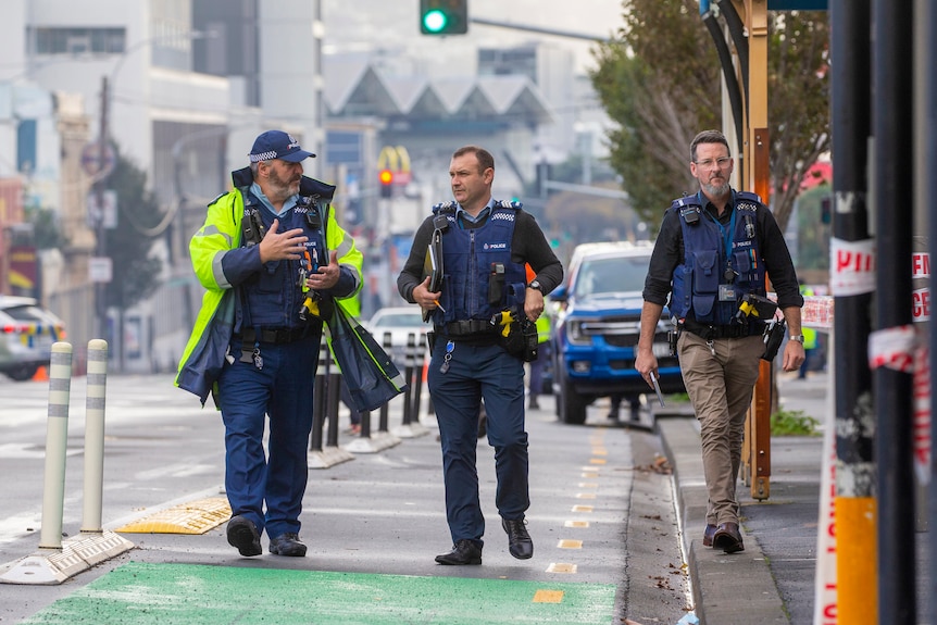 Three police walking down a city street.