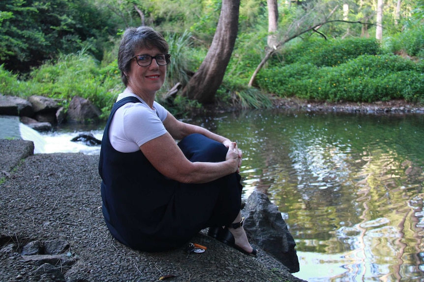 Janine Nicklin sitting by the Kedron Brook