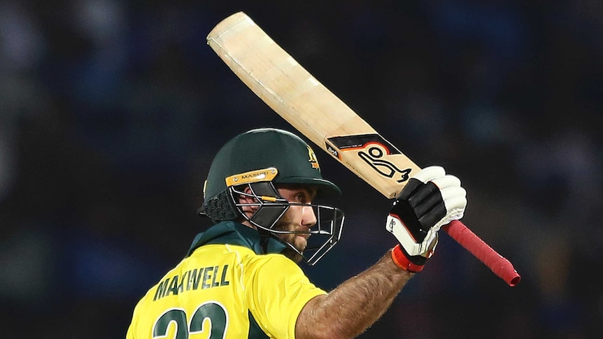Glen Maxwell holds his bat with his right hand above his head