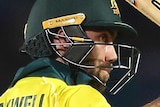 Glen Maxwell holds his bat with his right hand above his head