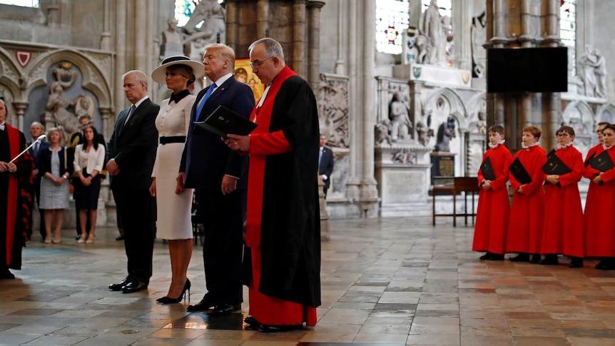 Prince Andrew with Donald and Melania Trump in a grand church standing in front of a choir, smartly dressed