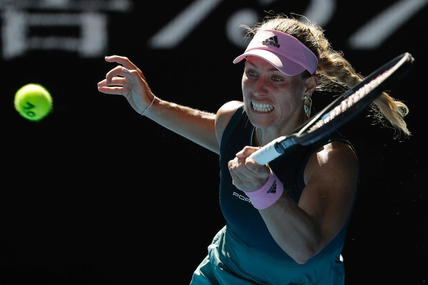 A tennis player grimaces as she stretches for a forehand in a tennis match.