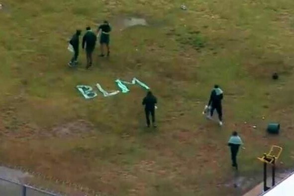 Inmates at Sydney's Long Bay jail spell out the letters 'BLM' using clothing on grass.