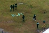 Inmates at Sydney's Long Bay jail spell out the letters 'BLM' using clothing on grass.