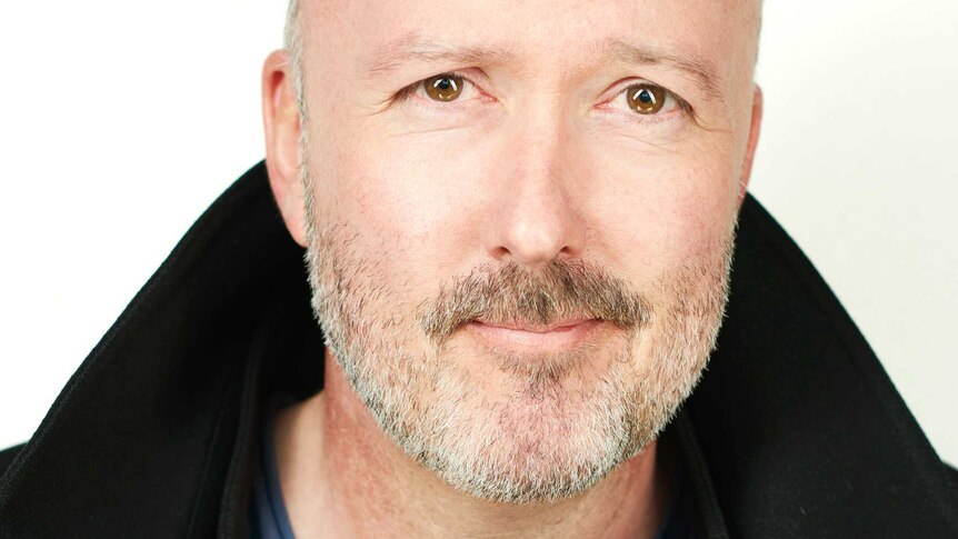 Head shot of the author smiling at the camera in front of a white background