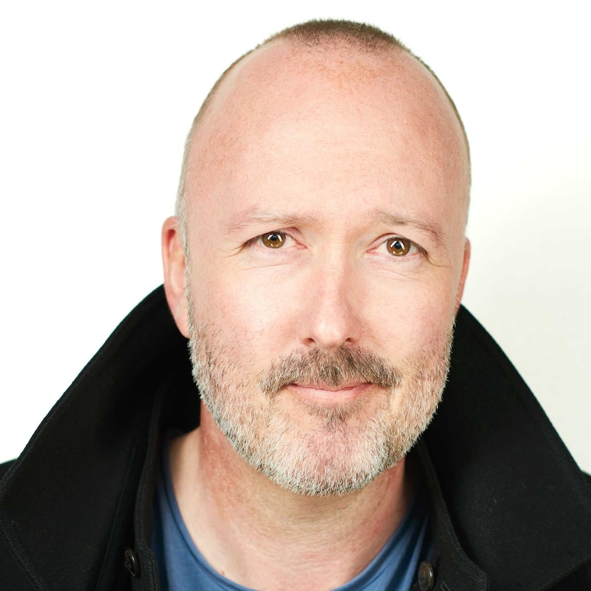 Head shot of the author smiling at the camera in front of a white background