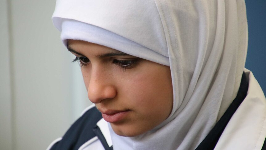 Asmaa looks down intently.