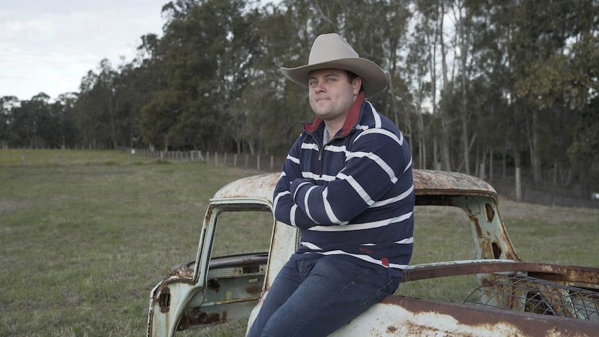 Farmer Josh Gilbert standing on his family's cattle farm in the Gloucester region in NSW for a story about farmers and climate.