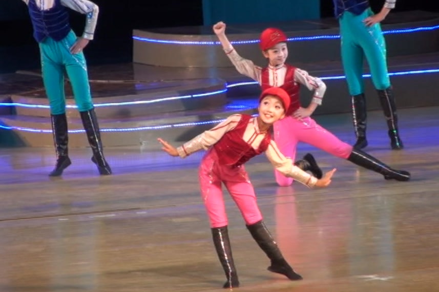 A group of children wearing costumes perform a dance in North Korea