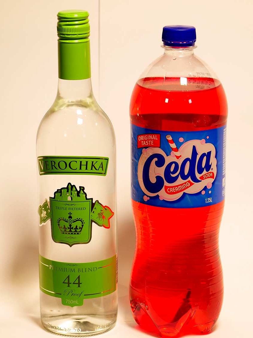 A bottle of clear alcoholic liquid and a bottle of pink soft drink