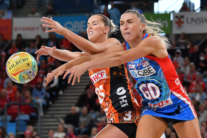 A Giants Super Netball player contest for the ball alongside a Swifts opponent.