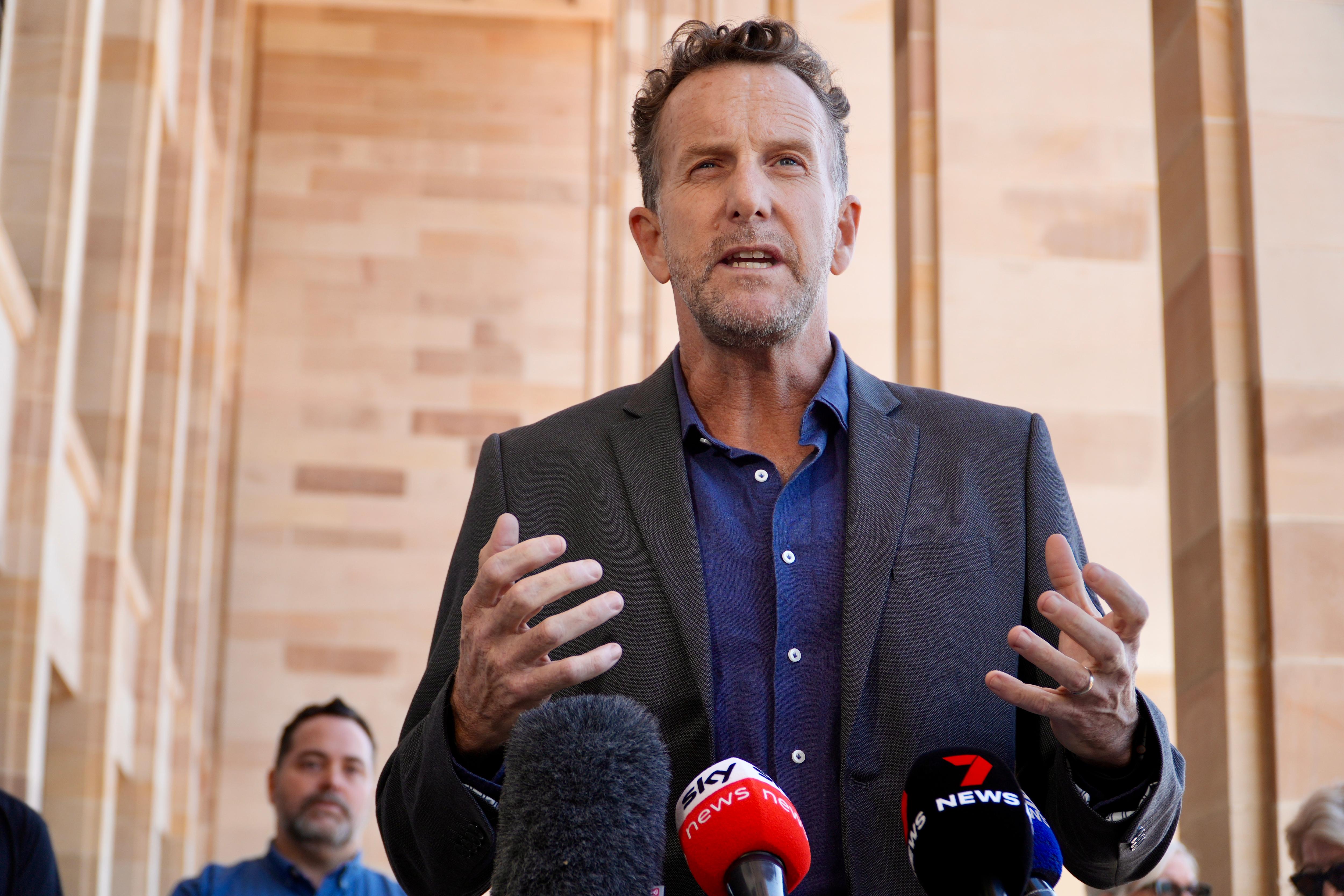 A man in a jacket and shirt talking outside WA parliament.