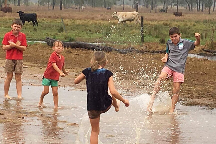 Kids having fun in puddles on a property near St Lawrence after the overnight downpour