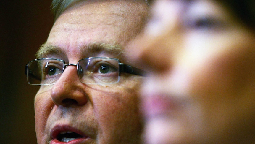 Kevin Rudd speaking while Julia Gillard is blurred in the foreground.