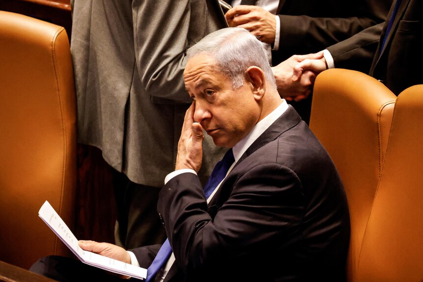 Benjamin Netanyahu touches his face