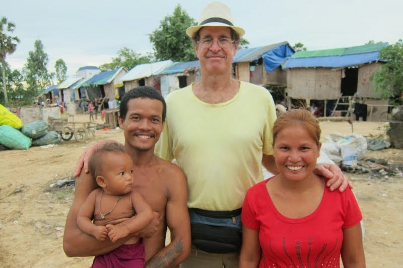 James Ricketson stands with a man, woman and child in Cambodia.