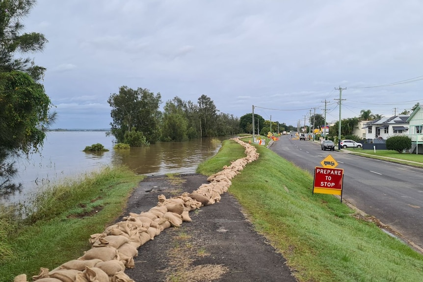 A river next to a road with sandbags