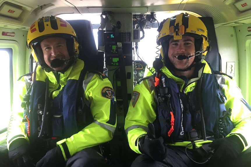 Sergeant Kriss Lawler and intensive care flight paramedic Charles Wendell-Smith inside a helicopter.