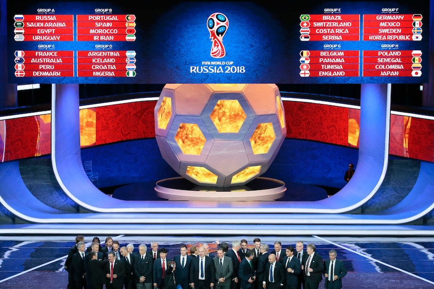 The coaches of the qualified teams pose for a group photo at the end of the 2018 soccer World Cup draw.